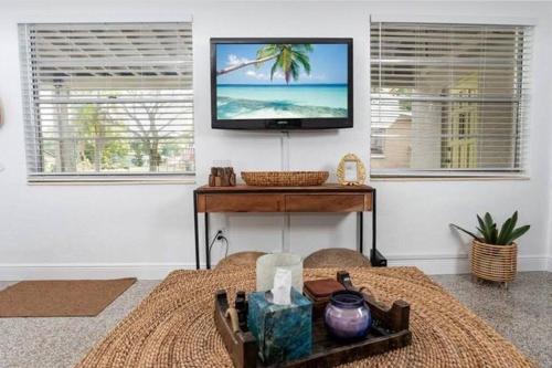 a living room with a flat screen tv on a wall at Private Oasis at Palm Casita in St. Petersburg