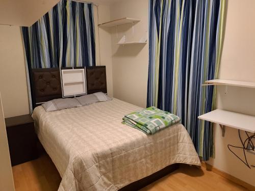 un pequeño dormitorio con una cama con una manta. en Departamento amoblado en Arequipa, Cerro Colorado - Plaza las Américas, en La Libertad