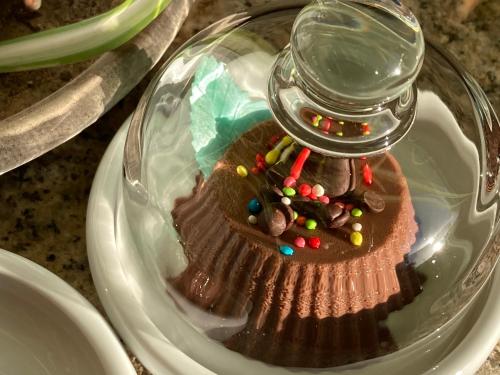 a glass plate with a chocolate dessert with a jar on top at Villa Franci in Santa Teresa Gallura