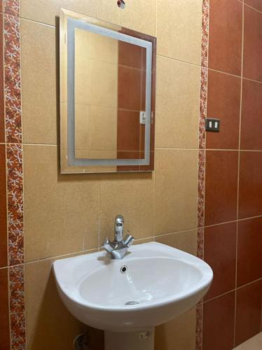 a white sink in a bathroom with a mirror at Alhejaz Luxurious Apartment in Cairo