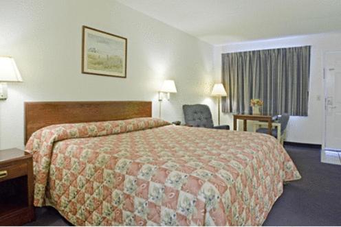 a hotel room with a large bed and a desk at Americas Best Value Inn Dayton in Dayton