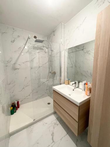 une salle de bain blanche avec une douche et un lavabo dans l'établissement Appart ultra moderne carré d or centre Marseille, à Marseille