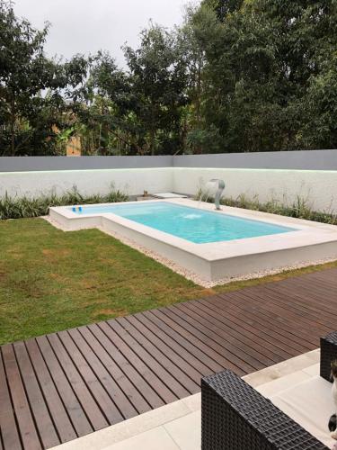 a swimming pool in the middle of a yard at Casa Luxo com piscina a 500 metros da praia in Florianópolis