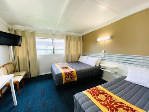 a hotel room with two beds and a tv at Mid Valley Motel in Morwell