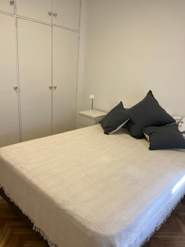a bedroom with a large bed with black pillows at Departamento luminoso en Rosario centro in Rosario