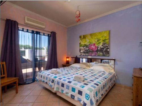 1 dormitorio con cama y ventana grande en Oceanfront Villa - 8 rooms, 2 kitchens with pool, billiard table and Beach-Volleyball Court, en Carvoeiro