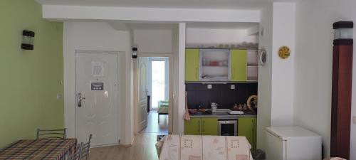 a kitchen with green and white cabinets and a table at Apartments Vela - Pestani, Ohrid in Ohrid