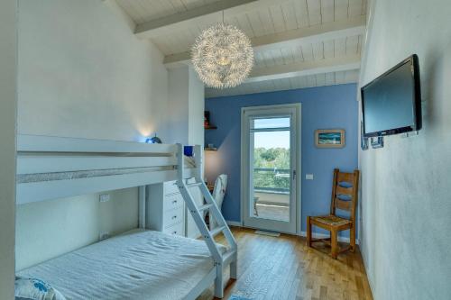 - une chambre avec des lits superposés, une télévision et un lustre dans l'établissement La Casa degli Ulivi appartamento in villa con patio, à Quartu SantʼElena