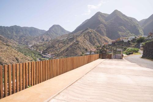 a wooden fence with mountains in the background at BASÂLTO Casas Rurales in Hermigua