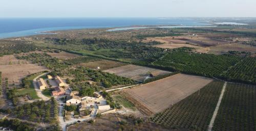 an aerial view of a farm with a field and the ocean at Casette Marianeddi -Agriturismo Marianeddi in Noto