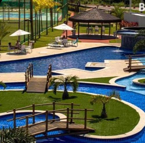 a large swimming pool with benches and umbrellas at Flat Muro Alto Porto de Galinhas in Porto De Galinhas