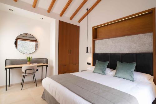 sypialnia z dużym łóżkiem i biurkiem w obiekcie BASÂLTO Casas Rurales w mieście Hermigua