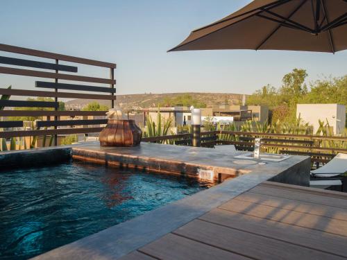 a swimming pool with an umbrella on top of a building at Casa No Name Small Luxury Hotel in San Miguel de Allende