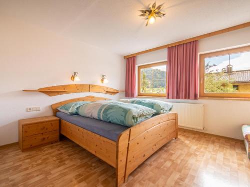 a bedroom with a wooden bed and a window at Chalet Blaserhof in Zell am Ziller