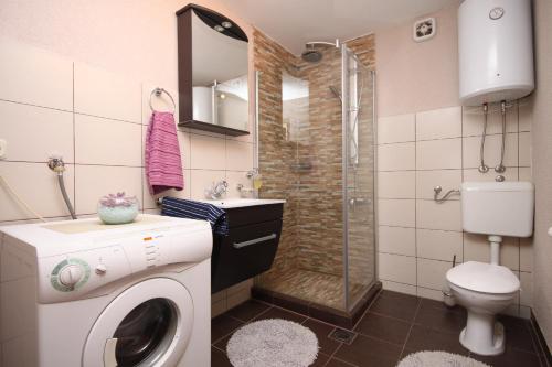uma casa de banho com uma máquina de lavar roupa e um chuveiro em Apartments with a parking space Jelsa, Hvar - 5703 em Jelsa
