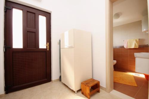 a white refrigerator in a room with a door at Apartments with a parking space Zavala, Hvar - 8773 in Zavala