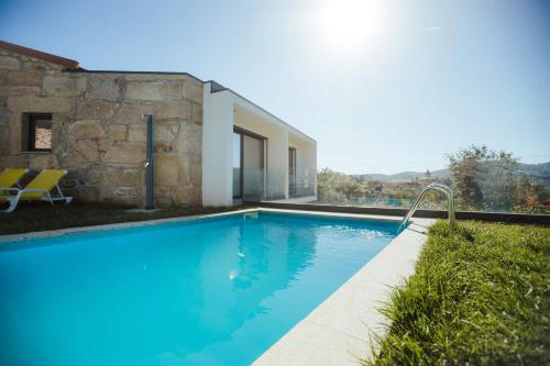 a swimming pool in front of a house at Casa da Vila - Pool & Hot Tub with Mountain View in Gerês in Terras de Bouro