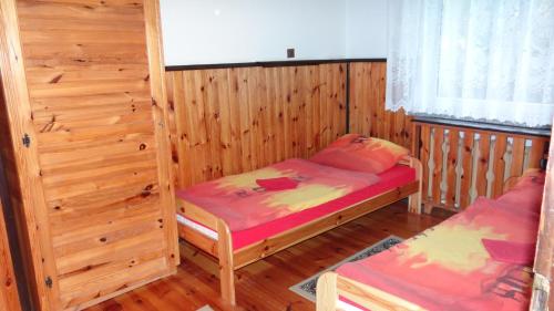 a room with two beds in a wooden cabin at Ośrodek Wypoczynkowy "Hotel Korona" in Mostowice