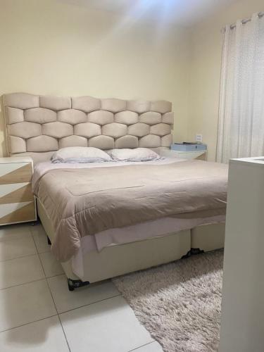 um quarto com uma cama grande e uma grande cabeceira. em Casa com piscina cabo frio em Cabo Frio