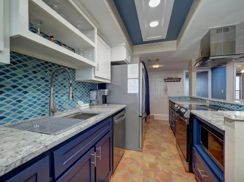 a large kitchen with blue tiles on the wall at Costa Crinks at Aransas Princess in Port Aransas