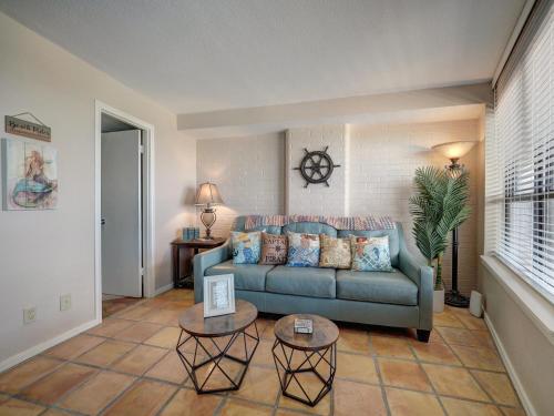 a living room with a blue couch and two tables at Costa Crinks at Aransas Princess in Port Aransas