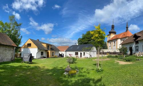 een tuin met een groep huizen en een kerk bij Relax apartmány na statku u Orlické přehrady in Klučenice