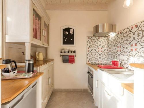 - une cuisine avec des placards blancs et du carrelage rouge et blanc dans l'établissement Gîte urbain de charme avec terrasse, vélos et équipements bébé, à 10 min de Nantes - FR-1-306-802, à Saint-Sébastien-sur-Loire