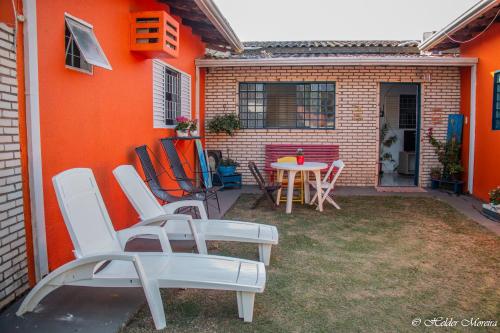 a patio with chairs and a table in front of a house at Pousada Manga Rosa in Chapada dos Guimarães