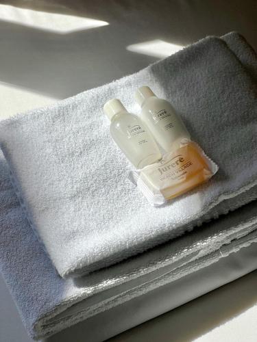 two bottles of soap sitting on top of towels at Jurerê Beach Village - Studio Vista Mar in Florianópolis