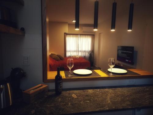 una mesa con dos vasos y un espejo en una habitación en Studio Soho 53 en La Plata