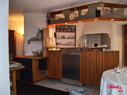een keuken met houten kasten en een zwarte koelkast bij L'Auberge in Walldorf