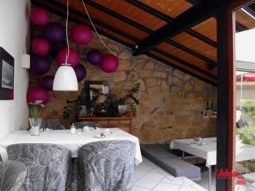 a dining room with two tables and a stone wall at L'Auberge in Walldorf