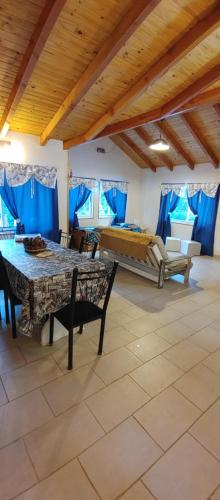 Habitación con mesa, cama y cortinas azules. en Casa turistica Bella Estacion, en Villa La Angostura