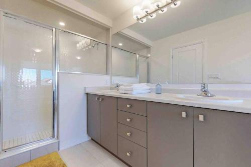 a bathroom with a sink and a large mirror at NEWLY BUILT LUXURIOUS 3BRM TOWN HS/AIRPORT/PARKING in Brampton