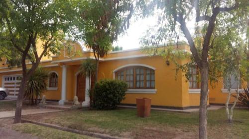 a yellow house with trees in front of it at Rincón Spa Seule in Ciudad Lujan de Cuyo