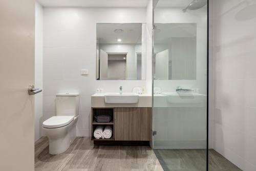 a bathroom with a sink and a toilet and a mirror at Quest Innaloo in Perth