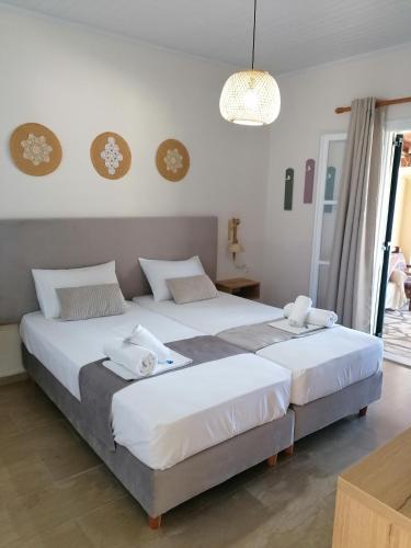 two beds in a room with white walls at Vicky's Panoramic View Apartments in Pelekas
