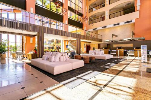 a lobby with two white couches in a building at Jurerê Beach Village - Suíte in Florianópolis