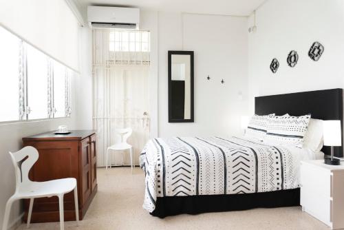 um quarto com uma cama, uma secretária e uma cadeira em Casa Isabel B&B em San Juan