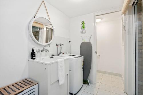 a white bathroom with a sink and a mirror at Eastpoint 3 in Byron Bay