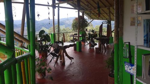 Habitación con balcón con mesas y sillas. en Hostal y Camping Los Girasoles, en Salento