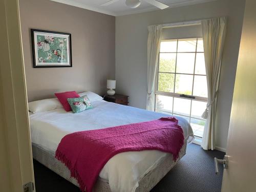 a bedroom with a large bed and a window at Perfect on Pymble Ave in Inverloch