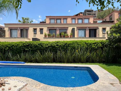 a house with a swimming pool in front of a house at Cousy Condo in the historic center of San Miguel de Allende, incredible view, pool, BBQ, 3 blocks from the main parish in San Miguel de Allende