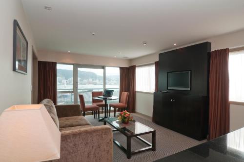 a living room with a couch and a tv at Copthorne Hotel Wellington, Oriental Bay in Wellington