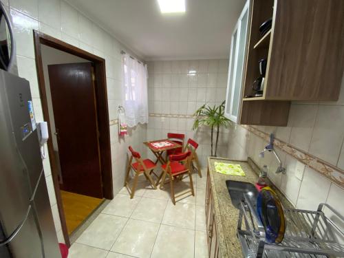 a small kitchen with a table and chairs in it at Apto com garagem no centro de Nova Friburgo in Nova Friburgo
