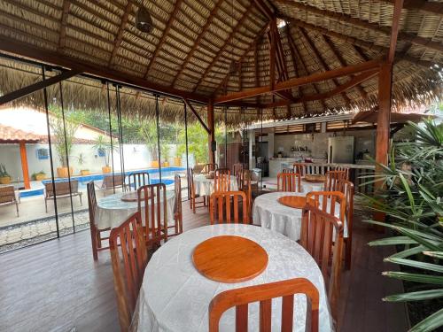 a restaurant with tables and chairs and a kitchen at Villa Éden in Alter do Chao