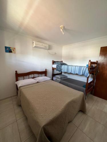 a bedroom with two beds and a fan at Casa em Peroba/Maragogi in Maragogi