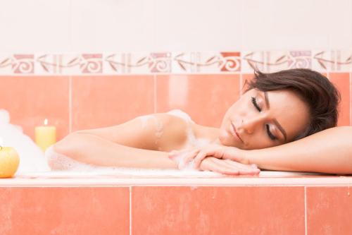 una mujer acostada en una bañera en Inn Express Hotel Tula, en Tula de Allende