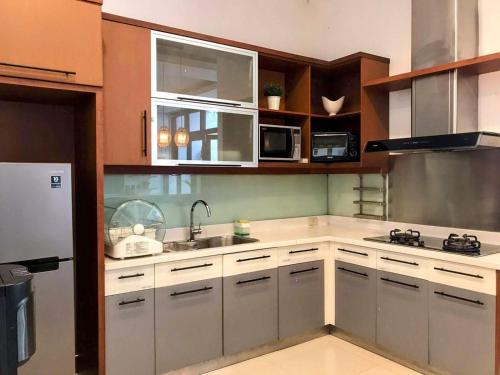 a kitchen with white cabinets and stainless steel appliances at Cottonwood 4BR Villa Sutami with Pool Netflix BBQ in Bandung