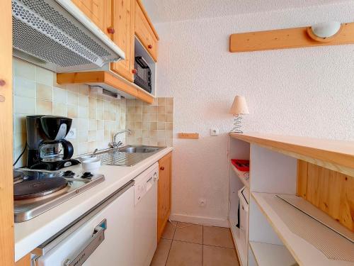 une petite cuisine avec un évier et un comptoir dans l'établissement Studio lumineux avec balcon Sud, ski aux pieds, 24 m², 4 pers., parking gratuit - FR-1-344-945, aux Menuires